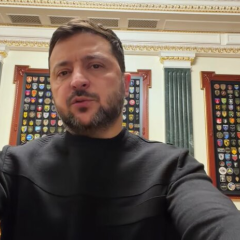 Зеленський на передньому плані у захисних одягах