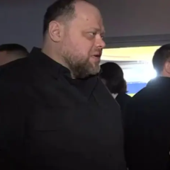 Мужчина с микрофоном на фоне Украинского Парламента
