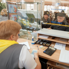 Пенсионер держит в руках деньги