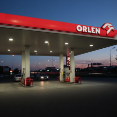 Логотип компанії Orlen на тлі польського прапора