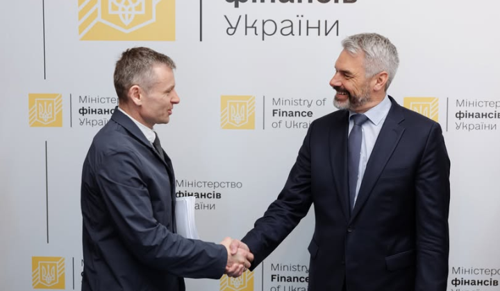 Фото блискучого головного деяча на тлі державного прапору України