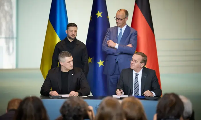 Zelensky and Merkel signing agreements in Berlin