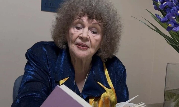 Lina Kostenko with a festive cake in the background