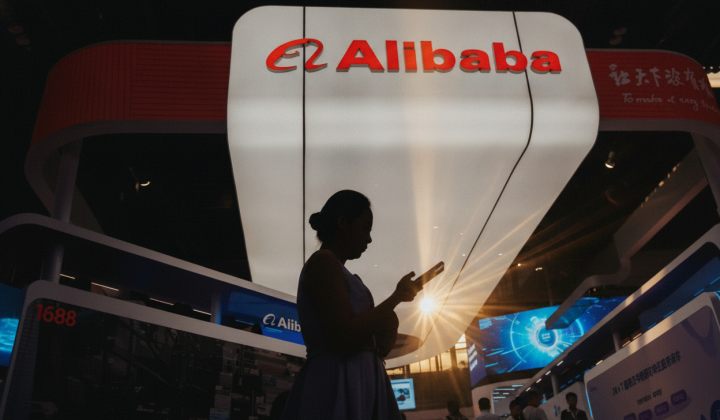Логотип компании Alibaba на фоне американского флага
