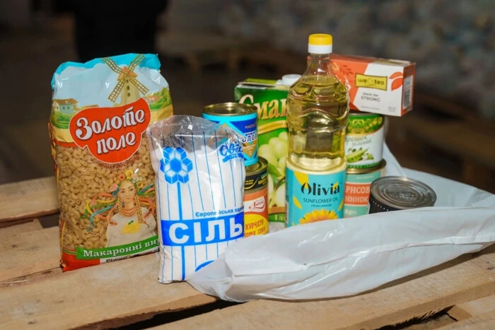 Группа людей раздает продуктовые наборы