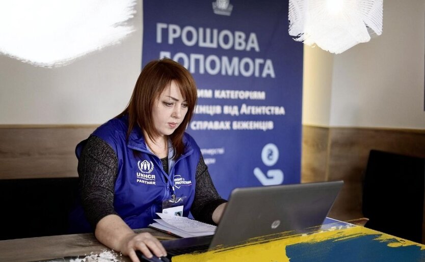 людина отримує допомогу готівкою