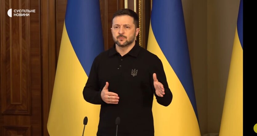 Зеленський на фоні прапорів України